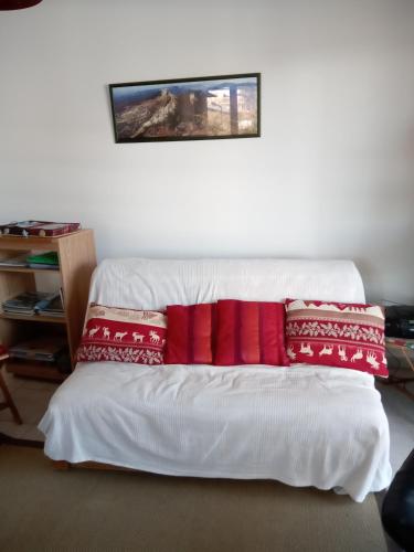 - un lit blanc avec des oreillers rouges dans l'établissement Vercors Source, à Villard-de-Lans