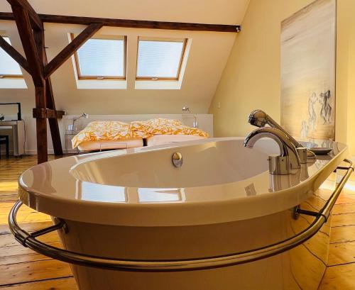 a large bath tub in a room with a bed at ARTvacanza Atelierhaus Edenkoben in Edenkoben