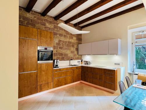a kitchen with wooden cabinets and a table in it at ARTvacanza Atelierhaus Edenkoben in Edenkoben