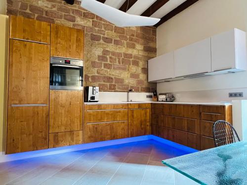 a kitchen with wooden cabinets and a brick wall at ARTvacanza Atelierhaus Edenkoben in Edenkoben