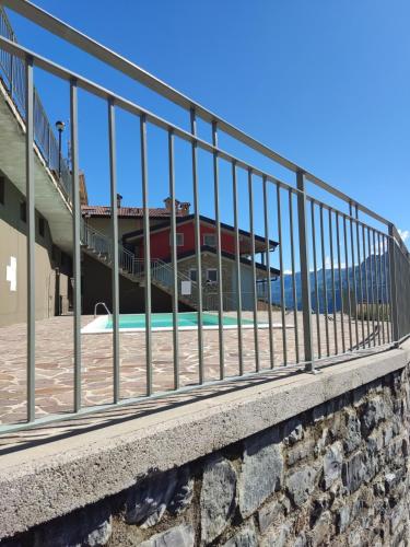a fence in front of a building with a pool at Blondie House - Pool & LakeView - by Host4U in Fonteno