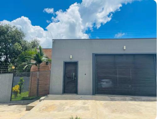 ein weißes Gebäude mit zwei Garagentüren darauf in der Unterkunft Casa alto padrão Rio Quente in Rio Quente