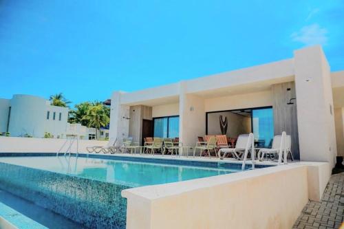 a villa with a swimming pool next to a house at Villas Eclipse by Andiani Travel in Isla Mujeres