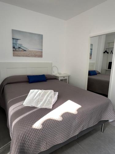 a bedroom with a bed with two towels on it at Ático Rocamar in La Restinga