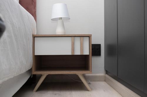 a bedside table with a lamp on it next to a bed at 28 Wilfred Villa in Johannesburg