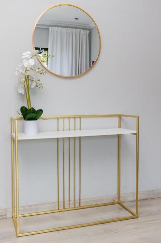 a gold and white console table with a mirror at 28 Wilfred Villa in Johannesburg