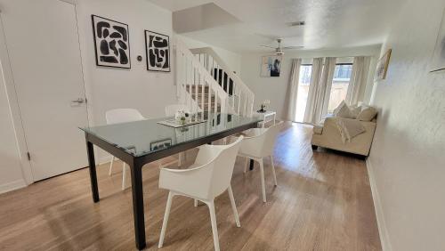 a dining room with a glass table and white chairs at Comfortable Townhome 2BR 1-5BA - Near UF & Shopping Dining in Gainesville