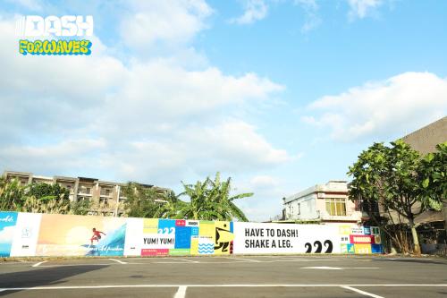 a street with a fence with signs on it at Dash Forwaves Hotel in Toucheng