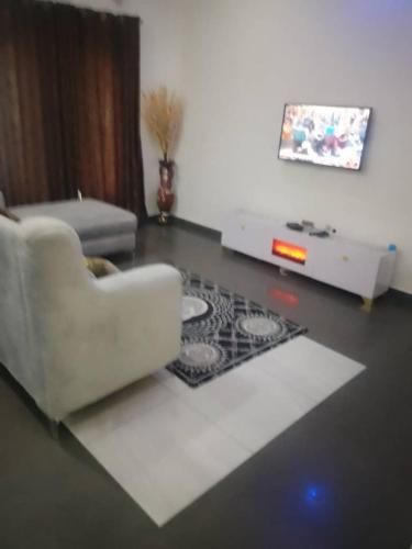 a living room with a white couch and a tv at London touch great 2bedroom with free WiFi 24hr light N65,000 in Port Harcourt