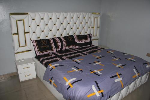 a bedroom with a large bed with a white headboard at London touch great 2bedroom with free WiFi 24hr light N65,000 in Port Harcourt