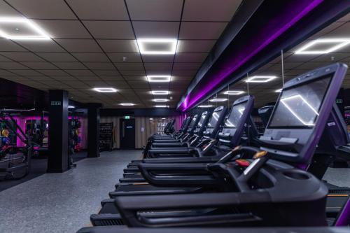 a row of treadmills in a gym with purple lighting at Best Western Plus The Quays Hotel Sheffield in Sheffield