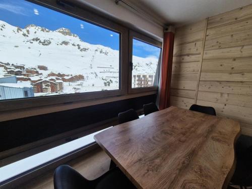 Cette chambre dispose d'une table en bois et d'une grande fenêtre. dans l'établissement Résidence Pontet B - Appartement rénové · Wifi · Balcon · Pied pistes MAE-1751, à Tignes