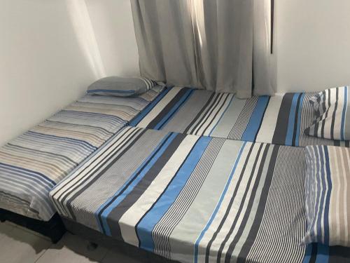 zwei Einzelbetten in einem Zimmer mit Fenster in der Unterkunft Flat no Winterville em Gravata in Gravatá