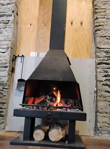 a stove with a fire inside of it at Cabaña con acceso a playa en Mehuin in Mehuín