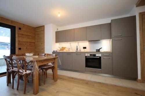 une cuisine avec une table en bois et une salle à manger dans l'établissement Résidence Les Cosmiques - Les Cosmiques MAE-6781, aux Houches
