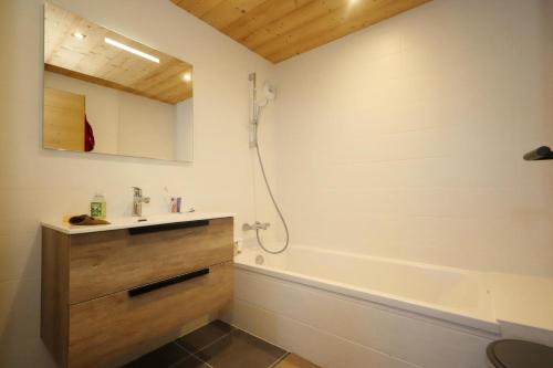 une salle de bain avec un lavabo et une baignoire dans l'établissement Résidence Les Cosmiques - Les Cosmiques MAE-6781, aux Houches