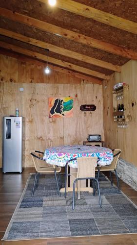 a table and chairs in a room with a refrigerator at Cabaña con acceso a playa en Mehuin in Mehuín