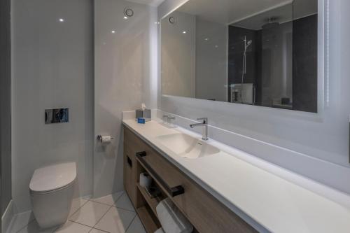 a bathroom with a sink and a toilet and a mirror at Best Western Plus The Quays Hotel Sheffield in Sheffield