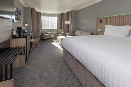 a hotel room with a large bed and a living room at Best Western Plus The Quays Hotel Sheffield in Sheffield