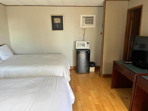 a hotel room with two beds and a television at Motel Clair Mont in Sainte-Agathe-des-Monts