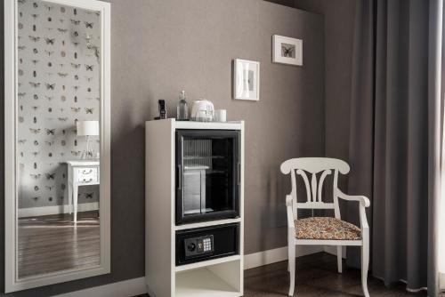 a room with a chair and a mirror at Maxxim Hotel & Loft in Ferrara