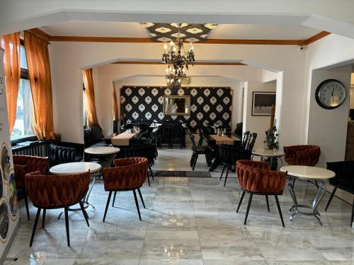 a dining room with tables and chairs and a chandelier at Hotel Gloria Budapest City Center in Budapest