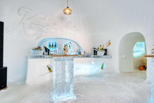 a white room with a table covered in ice at Grand Hotel des Bains Kempinski in St. Moritz