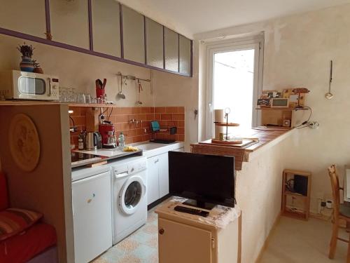 une cuisine avec un lave-linge et un micro-ondes dans l'établissement Appartement sympa centre historique de Nyons, à Nyons