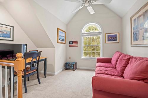 a living room with a red couch and a tv at Cozy Bungalow Close to Downtown in Harwich