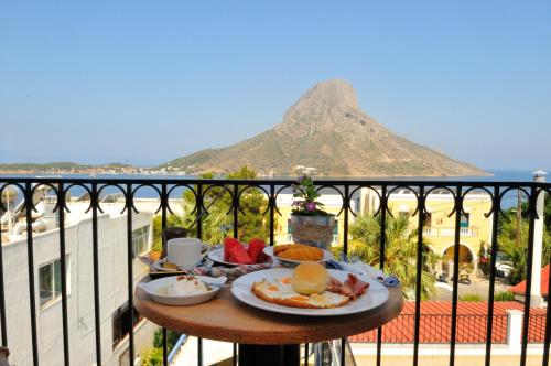 einen Tisch mit Frühstückszutaten auf einem Balkon mit Bergblick in der Unterkunft Vouros Palace in Masouri