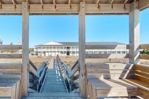 a wooden dock with a building in the background at Ocean Sands 136 in Atlantic Beach