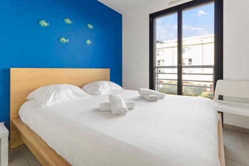 une chambre avec un grand lit blanc avec des serviettes dessus dans l'établissement Le Sud - Quiet - Spacious - AC - Private car park - Aerodrome, à Cannes