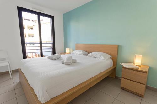 une chambre avec un grand lit avec deux serviettes dessus dans l'établissement Le Sud - Quiet - Spacious - AC - Private car park - Aerodrome, à Cannes