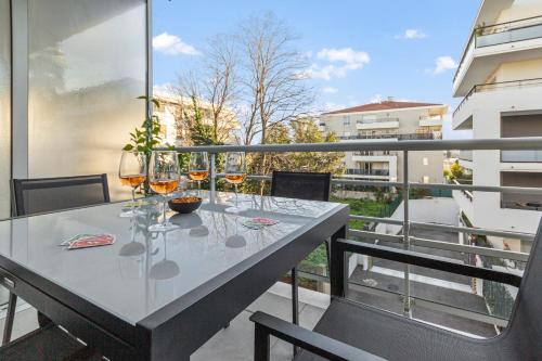 - une table sur un balcon avec des verres à vin dans l'établissement Le Sud - Quiet - Spacious - AC - Private car park - Aerodrome, à Cannes