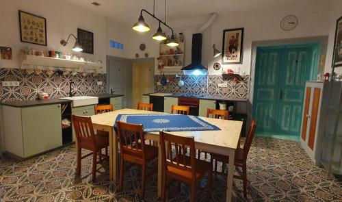 a kitchen with a table and chairs in a room at Csacsiország Vendégház in Nógrádsáp