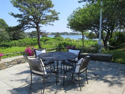 a black table and chairs with a view of the water at Luxury Waterfront with Game Room in Chatham