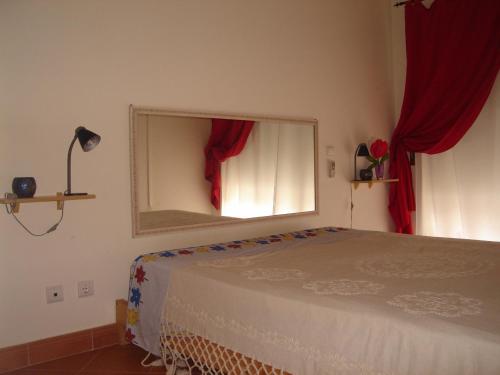 1 dormitorio con 1 cama con espejo y cortinas rojas en Caesar Apartment, en Lagos