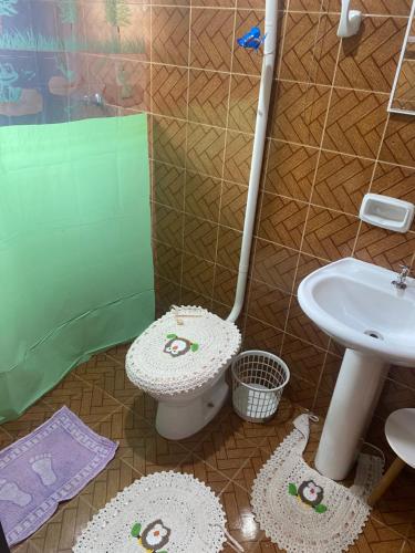 a bathroom with a toilet and a sink at Casa roxa in Itatiaia