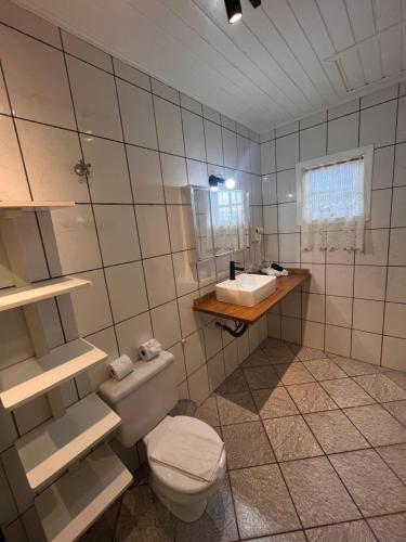 a bathroom with a toilet and a sink at Pousada do Vento in Campos do Jordão