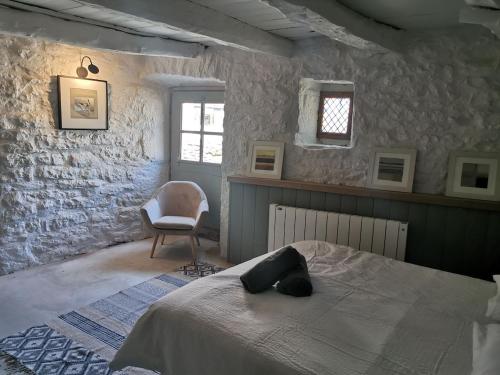 a bedroom with a bed and a chair at La Maison Médiévale à colombage en Quercy in Puylagarde