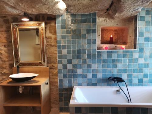 a bathroom with a tub and a sink and a mirror at La Maison Médiévale à colombage en Quercy in Puylagarde
