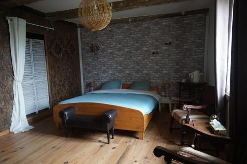 a bedroom with a bed and a brick wall at Chambre d'hôtes Juste-Confortable in Fleurey-lès-Lavoncourt