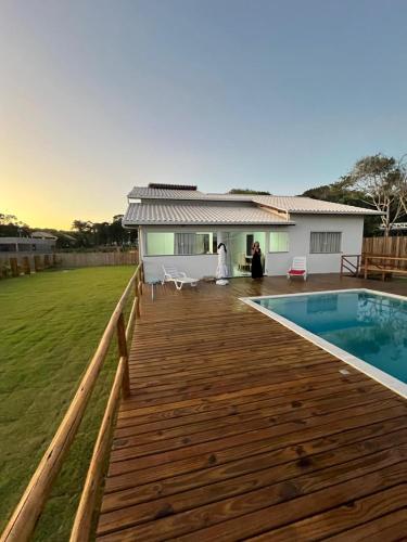 a wooden deck next to a house with a pool at vila sua casa 2 in Santo André