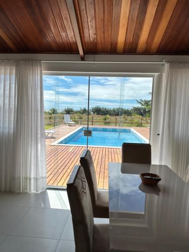 a living room with a table and a view of a pool at vila sua casa 2 in Santo André