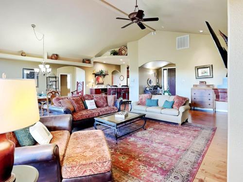 a living room with couches and a ceiling fan at High Expectations in Ruidoso