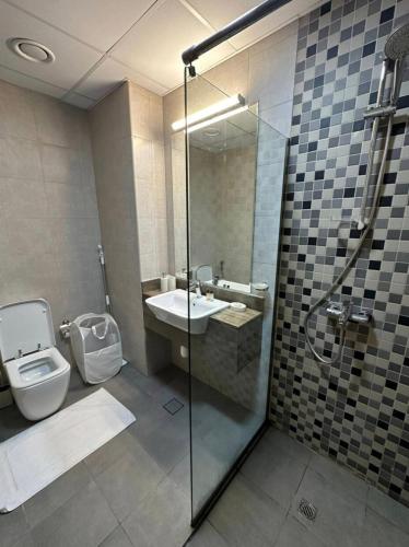 a bathroom with a shower and a sink and a toilet at Cozy, fully furnished, Kitchen equipped Studio apartment with all facilities in Dubai