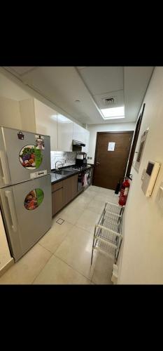 a kitchen with a stainless steel refrigerator and a stove at Cozy, fully furnished, Kitchen equipped Studio apartment with all facilities in Dubai