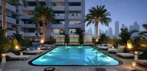 a swimming pool in the middle of a building with palm trees at Cozy, fully furnished, Kitchen equipped Studio apartment with all facilities in Dubai