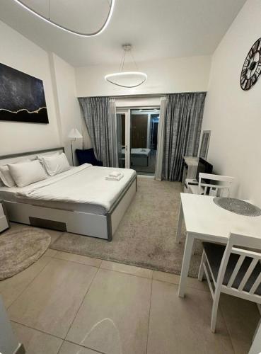 a large bedroom with a bed and a table at Cozy, fully furnished, Kitchen equipped Studio apartment with all facilities in Dubai