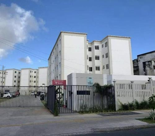 un edificio bianco con una recinzione di fronte di Apartamento porto dos mares a Salvador
